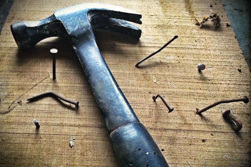 Hammer with nails in board