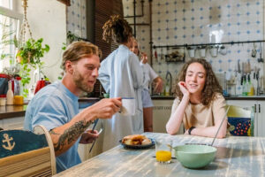 Diverse young people at a kitchen table in a sober living house