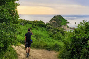 Man walking down a path toward the Cape of Rodon, Albania