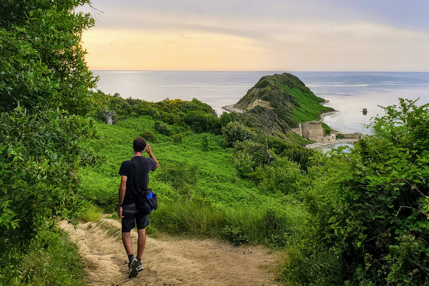 Man walking down a path toward the Cape of Rodon, Albania