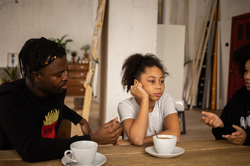 Sad child and two parents at dinner table